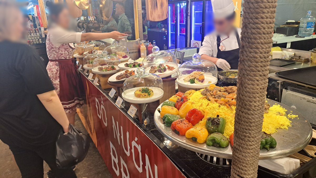 屋台でパエリアやお肉料理を出している