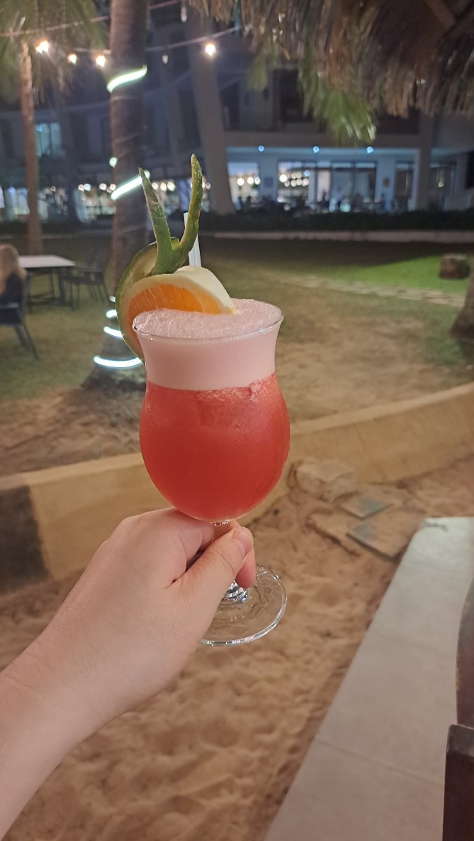 甘いカクテルを楽しみながらホテルの夜景や海を眺める時間