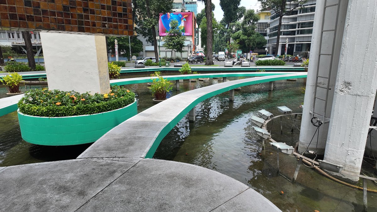 亀池の遊歩道と池の植栽、周辺の街並み