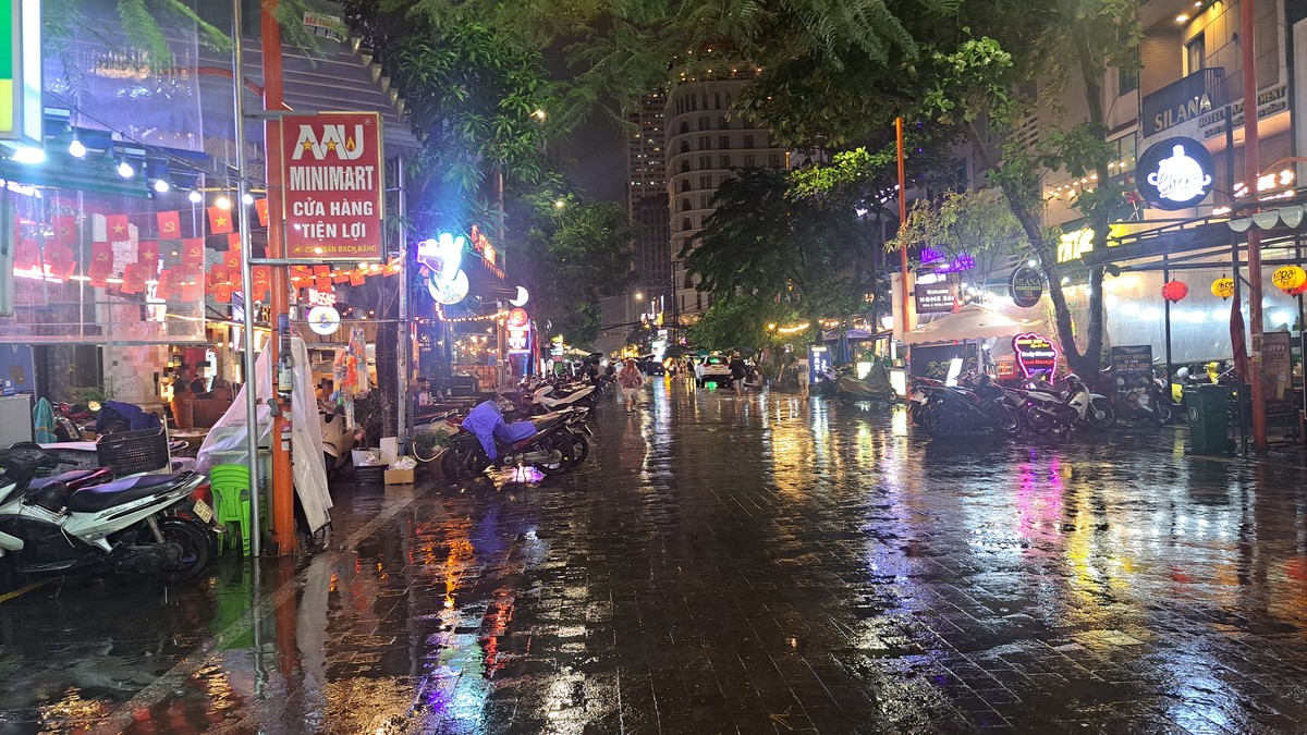 ネオンと提灯が映るAn Thuongの雨上がりの通り