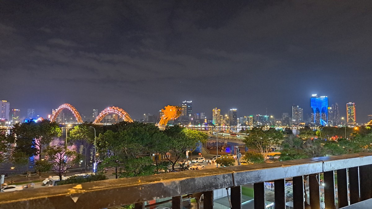 テラス手すり越しに見えるオレンジ色のドラゴンブリッジ夜景