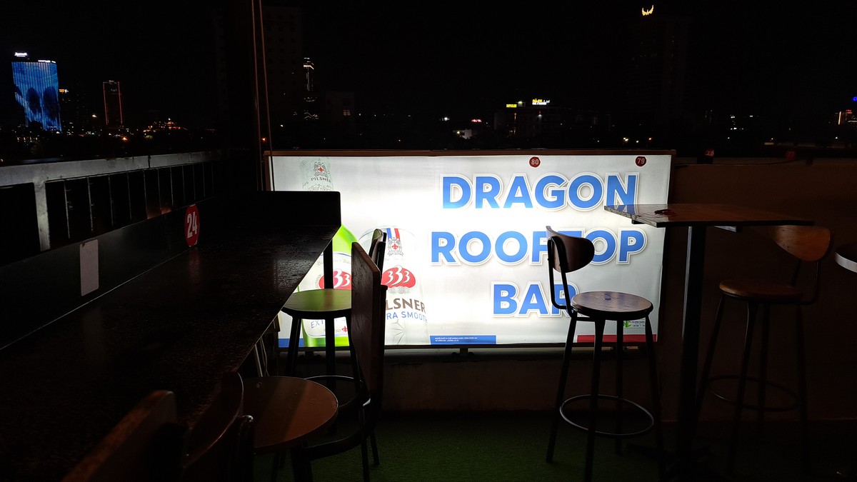 テラスに立つDRAGON ROOFTOP BARのライトボックス看板