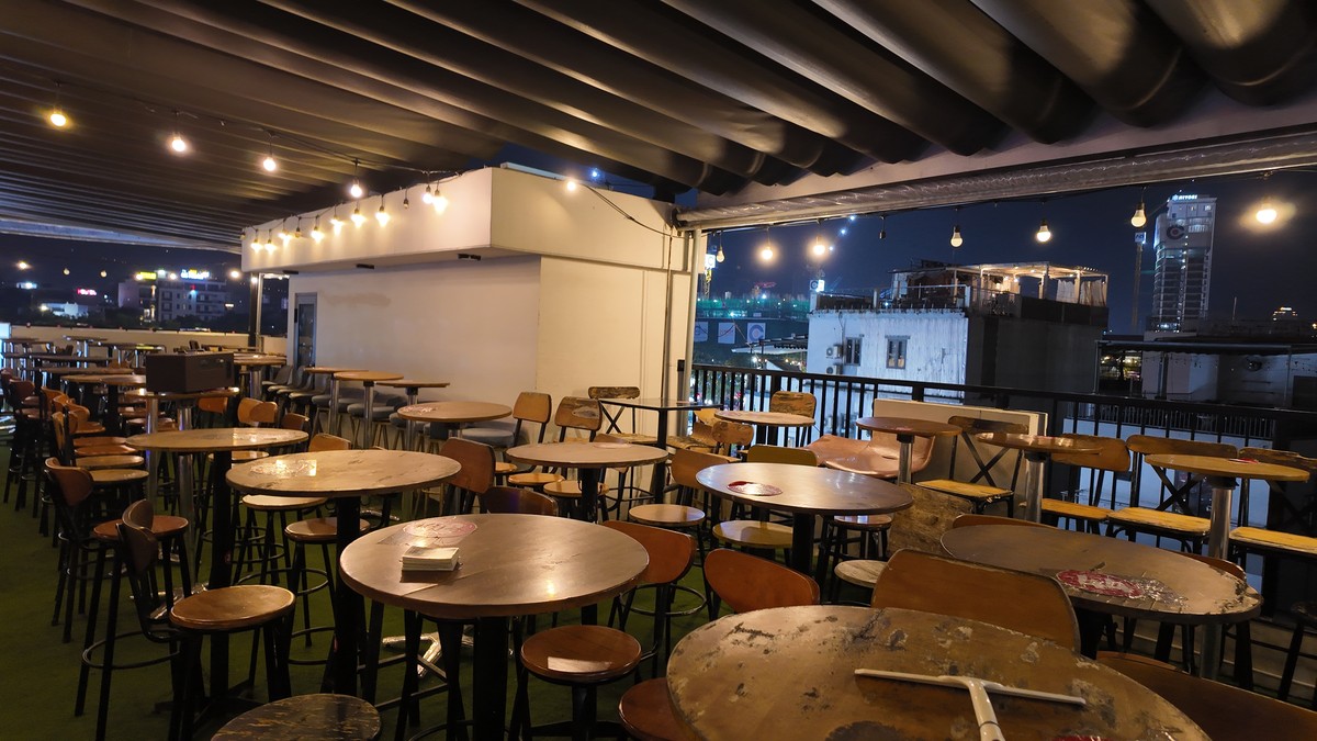 人工芝の広いテラスにテーブルが並ぶDragon Ball Rooftop Bar