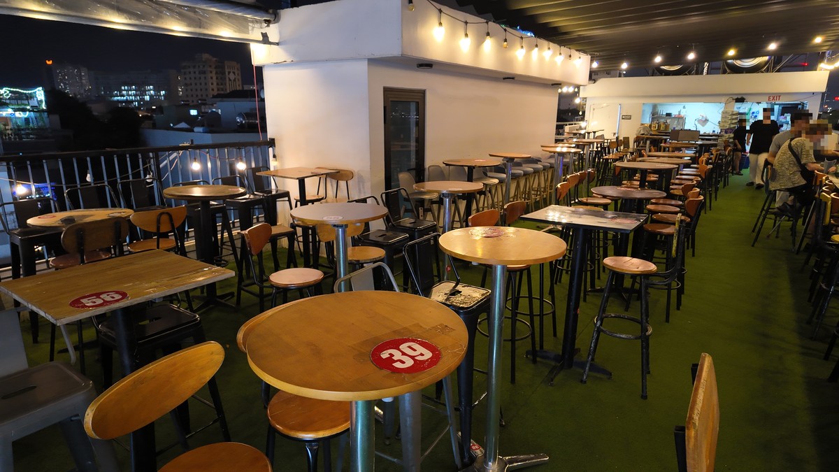 番号札付きテーブルが並ぶDragon Ball Rooftop Barの店内テラス