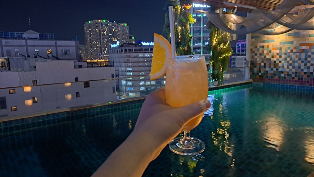 ホーチミンの夜景と超高層ビルの近景を楽しめる屋上プールの夜とカクテル