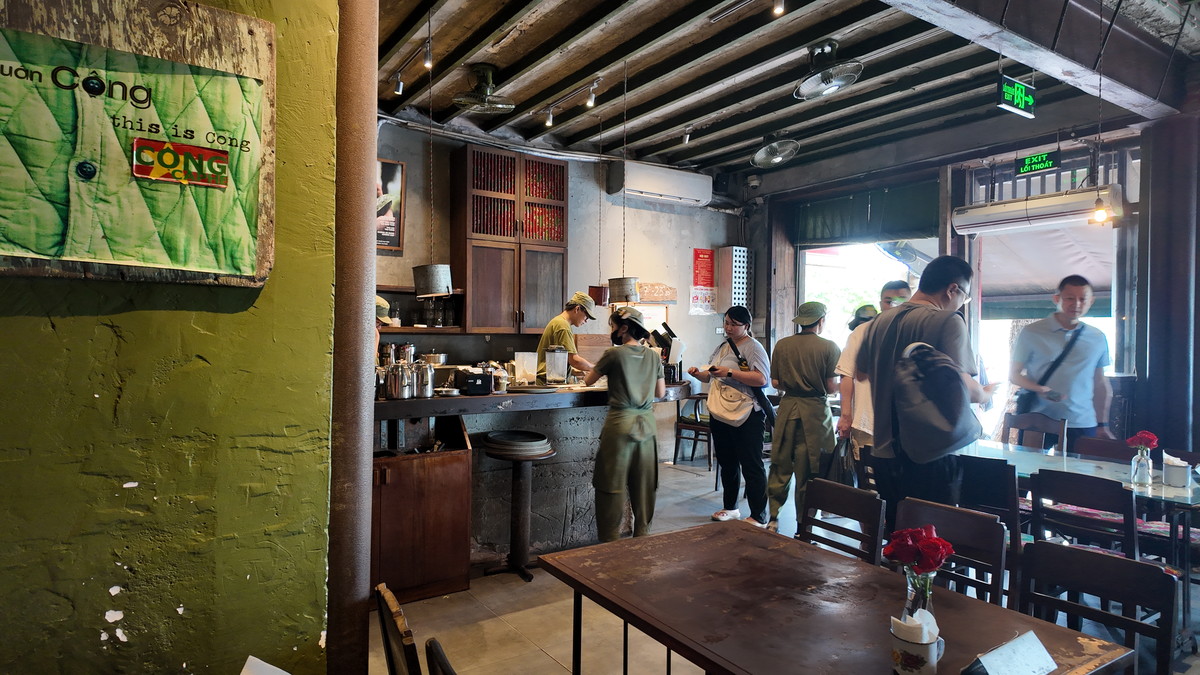 緑の壁とカウンターが続く「Cộng Cà Phê」の店内